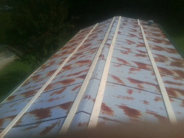 Rusted metal roof panels with new wood purlins before replacement — Storm Damage Roof Repair in South Hackensack by Roofing Brothers