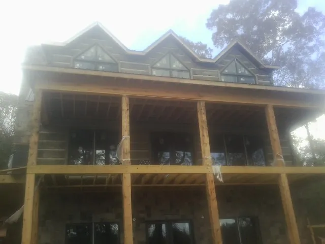 Dormers and porch framing on a large log home under construction — Roof Coating work by our crew in South Hackensack