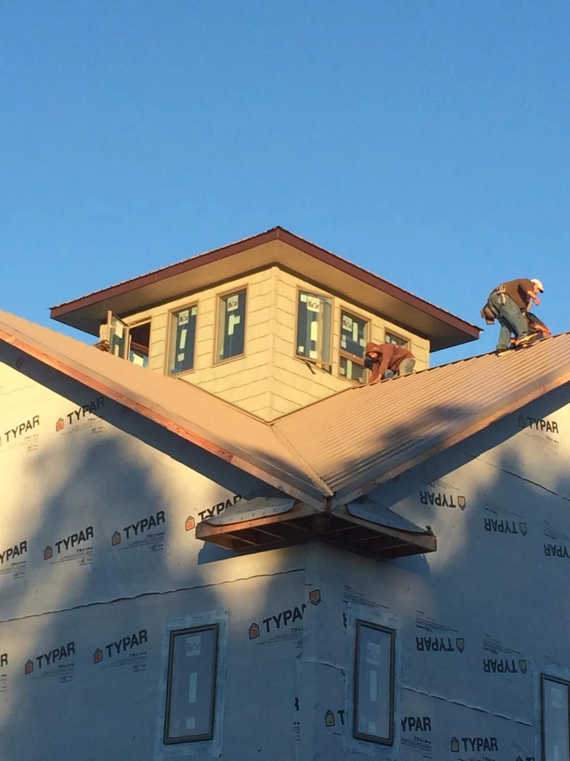 Roofers working around a rooftop cupola on a new metal roof at sunset — Roof Waterproofing in South Hackensack by Roofing Brothers